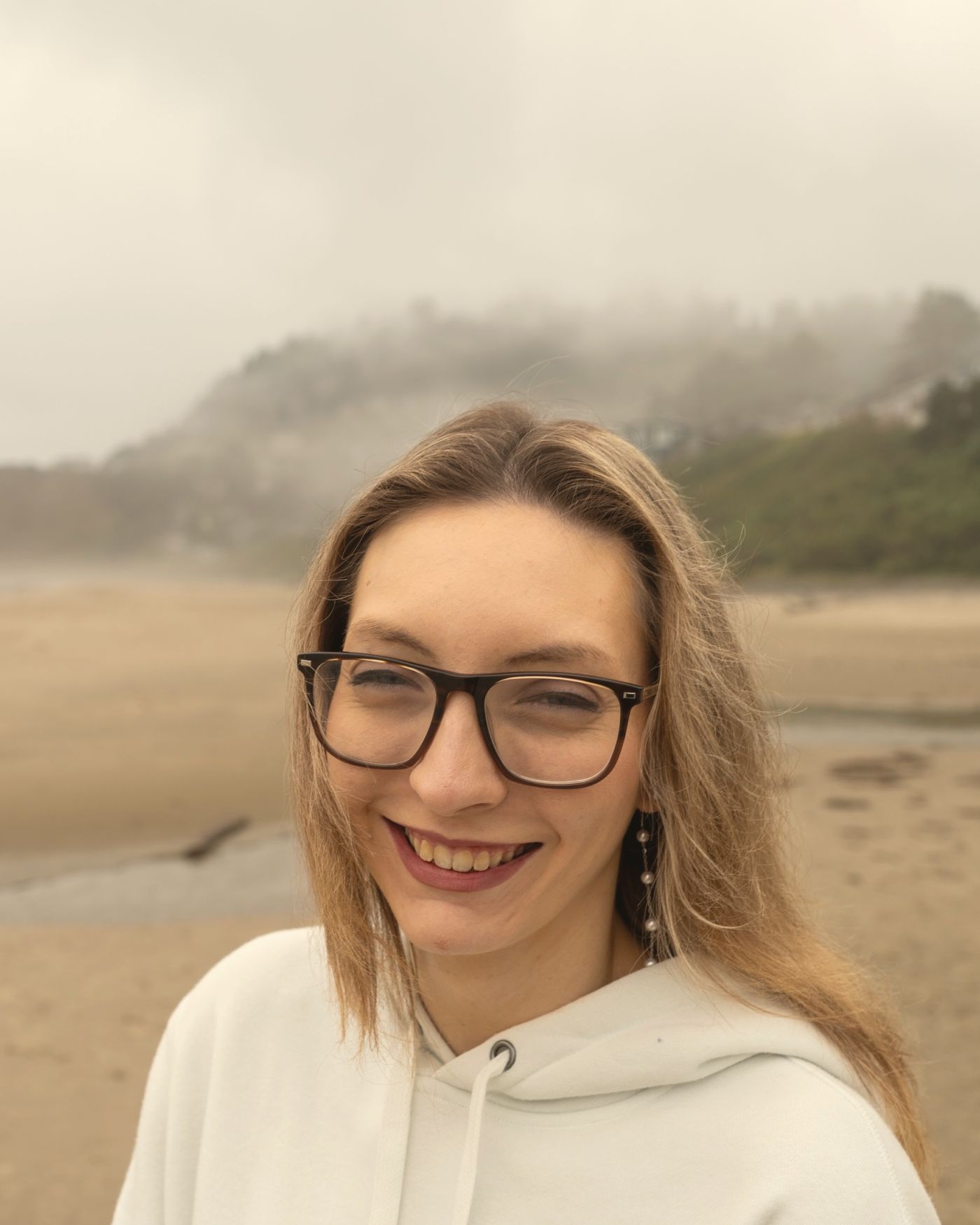 Portrait of Stephanie Meninga smiling on a misty beach